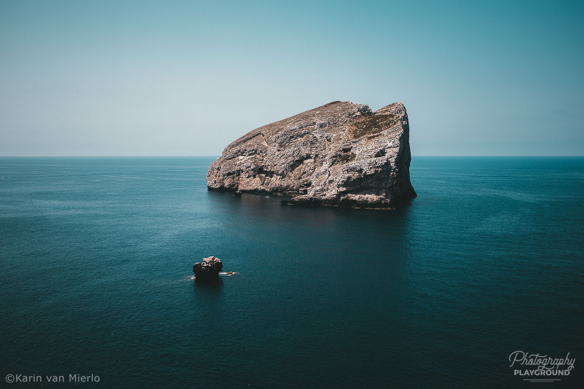 principles of composition in photography, photo composition examples, composition techniques, composition rules, negative space | Copyright Karin van Mierlo for Photography Playground. Photo: A big rock in the sea around Sardinia, Italy.