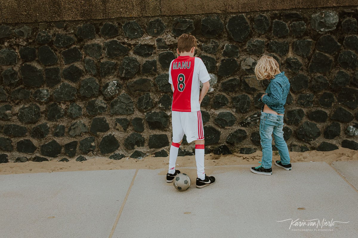 photographing children, photographing kids, child photography tips, tips for photographing kids, how to photograph kids | Photo: 2 brothers peeing against a wall  Copyright Karin van Mierlo | Photography Playground